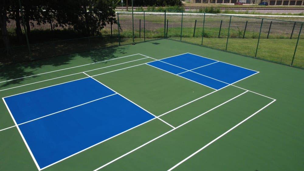 Finished green and blue pickleball courts converted from a tennis court with fresh white striping in Richardson, Texas