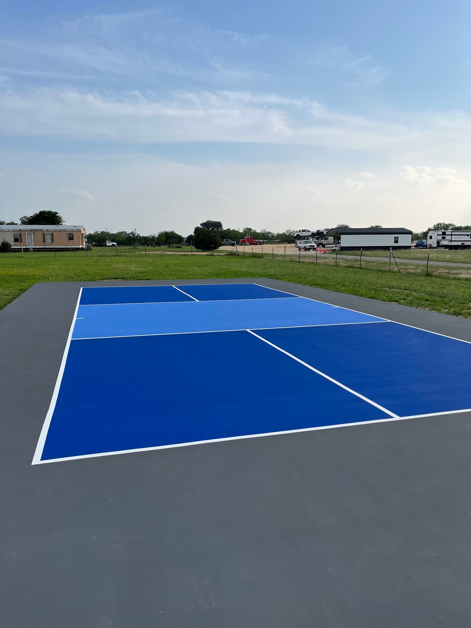 Finished blue and gray pickleball court on a rural property near San Antonio, Texas