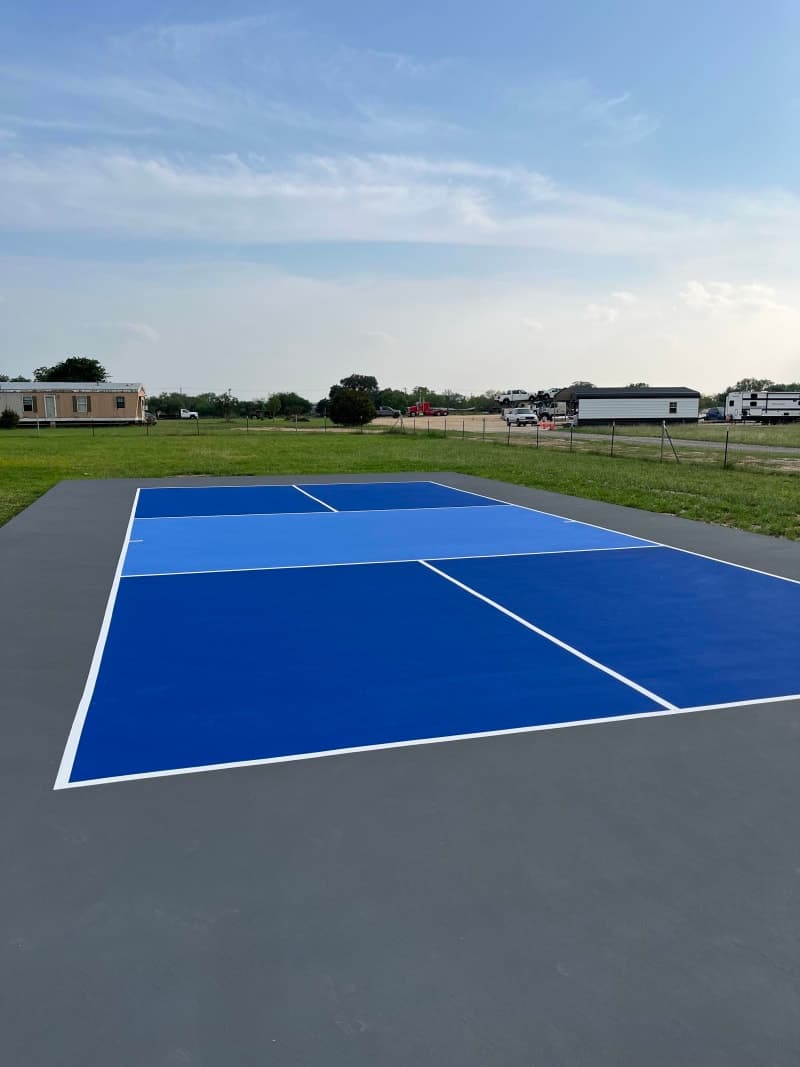 Finished blue and gray pickleball court on a rural property near San Antonio, Texas